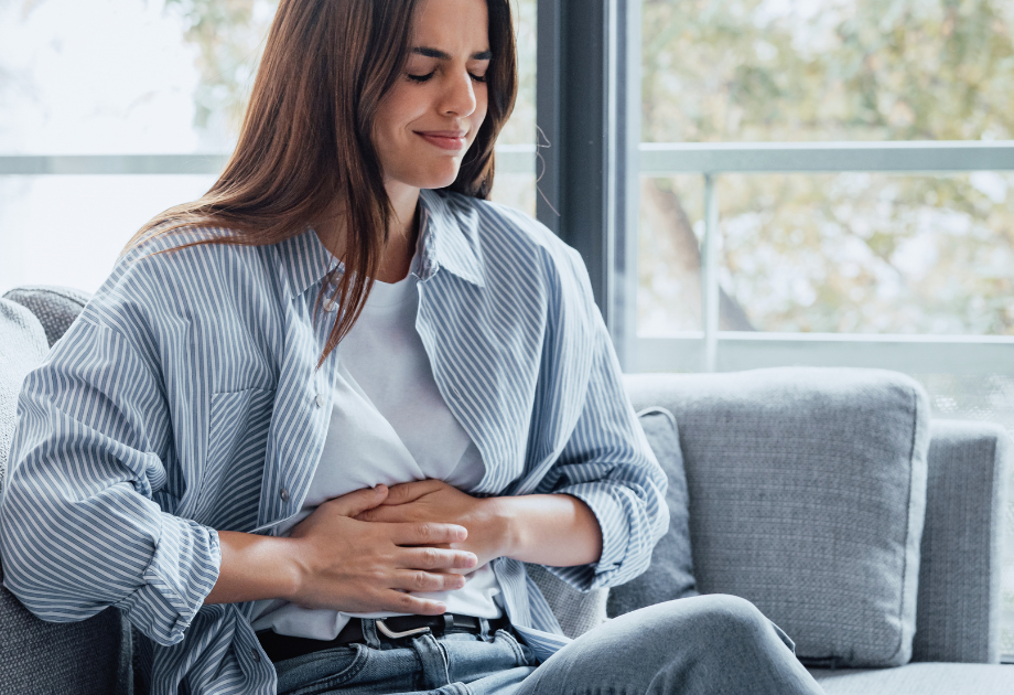 woman holding her stomach with a pained expression