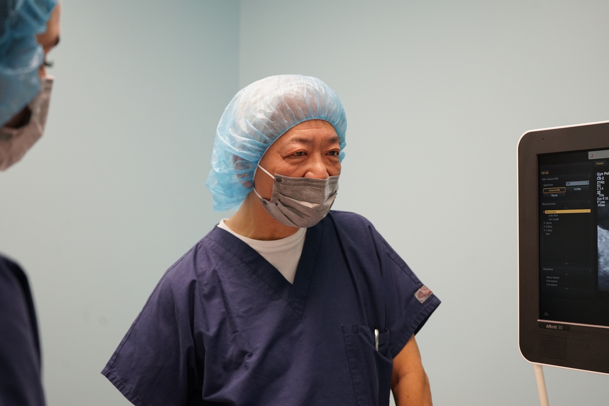 Dr. Chin in a mask and a disposable bonnet