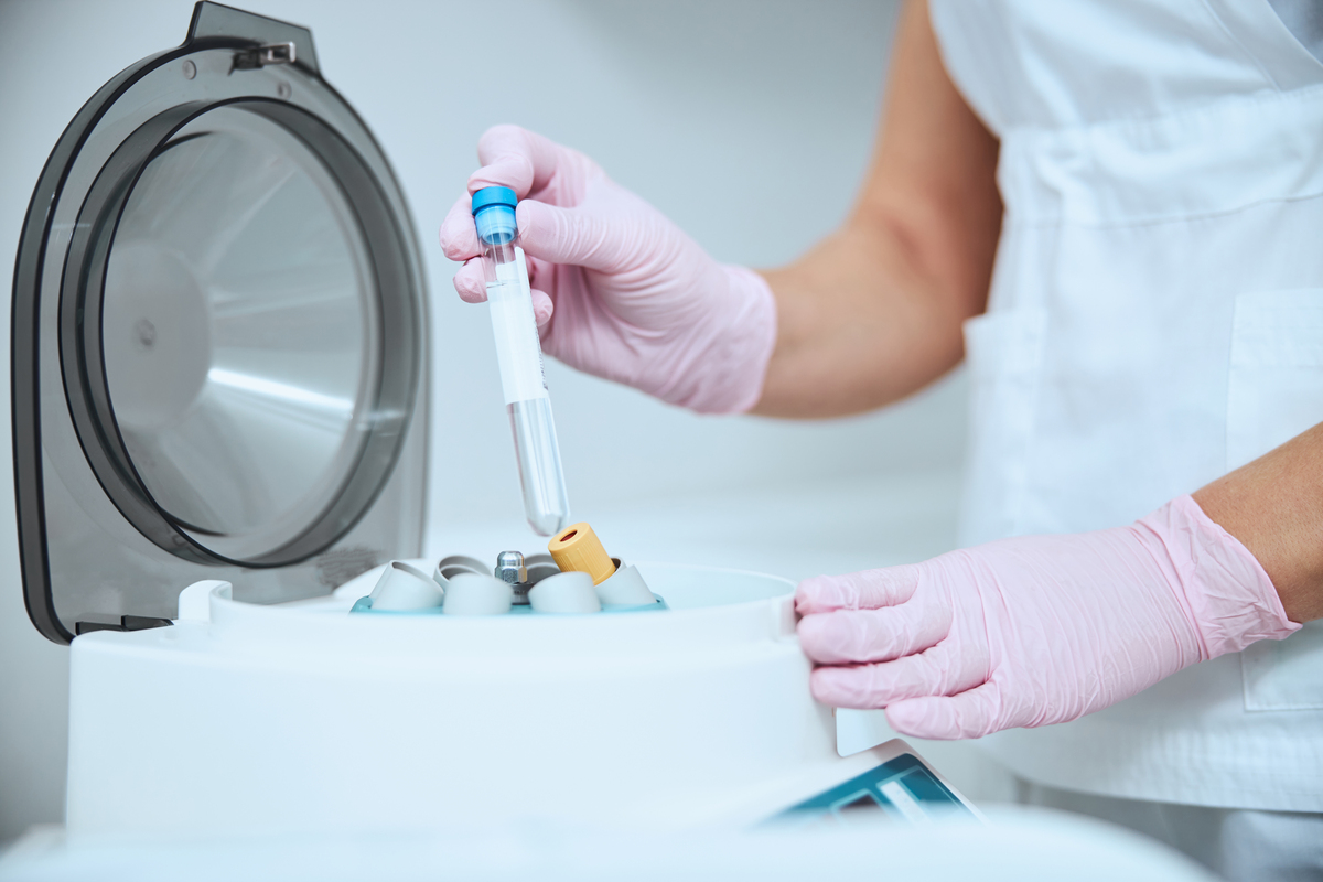 medical specialist putting a vial into a chamber