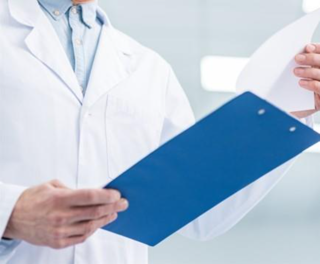 doctor holding a clipboard looking over papers