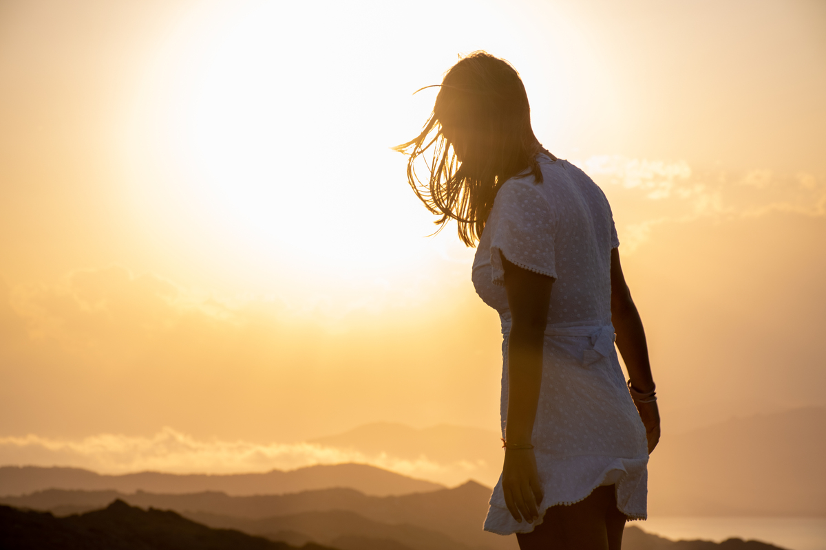 woman facing setting sun